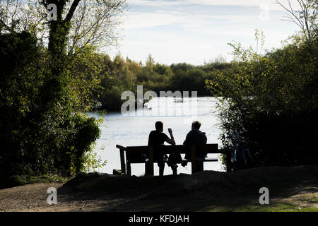 Zwei Männer saßen am See genießen Sie warmen Herbst Sonne Stockfoto