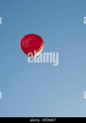 Rote Jungfrau heissluftballon in den klaren, blauen Himmel ohne Wolken von der untergehenden Sonne, wendover beleuchtet, Buckinghamshire Stockfoto