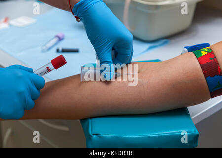 Der Arzt Blut in einer Spritze sammelt, Krankenschwester ...