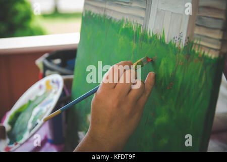 Artist holding Pinsel malen auf Leinwand Stockfoto