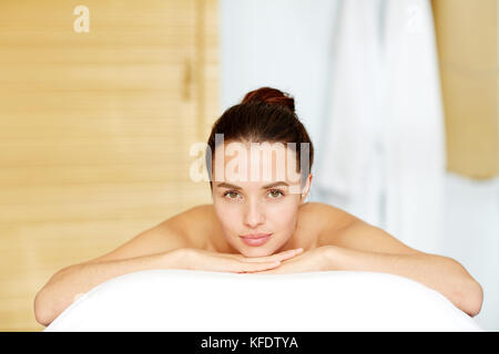 Entspannte Frau, die auf Massage wartet, während sie im Spa-Salon liegt Stockfoto