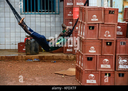 BURKINA FASO, Provinz Poni, Gaoua, Bier Pub, Brakina Bier Kästen, Mann in der Hängematte Stockfoto