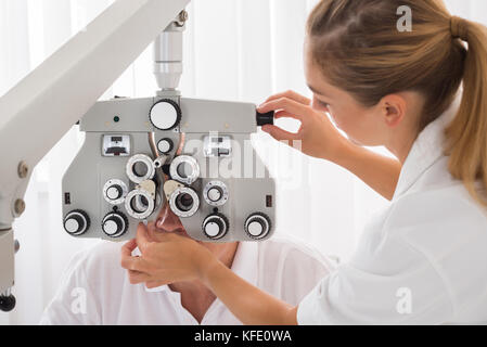 Gerne weibliche Optometriker tun Anblick Tests für Patienten in der Klinik Stockfoto