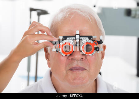 Close-up ein Augenarzt prüfen älteren männlichen Patienten Vision mit Trial Rahmen an Augenklinik Stockfoto