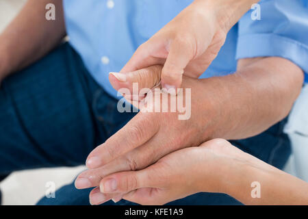 Nahaufnahme von einem Physiotherapeuten massieren Handfläche ein Mann Stockfoto