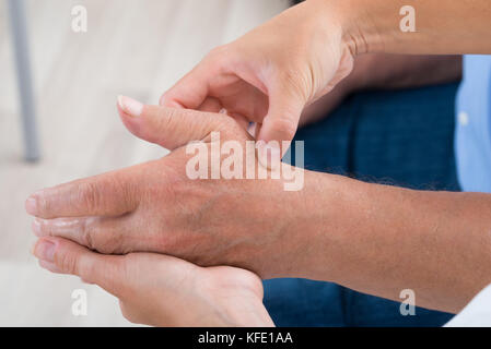 Nahaufnahme von einem Physiotherapeuten massieren Handfläche ein Mann Stockfoto