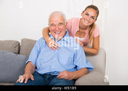 Portrait eines glücklichen jungen Frau mit ihrem Vater sitzt auf einem Sofa Stockfoto