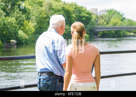 Ansicht der Rückseite eine junge Frau mit ihrem Vater auf der Suche am See Stockfoto