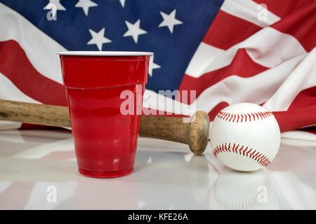 Red party Becher mit Holz bat und Baseball auf glänzende Oberfläche Stockfoto