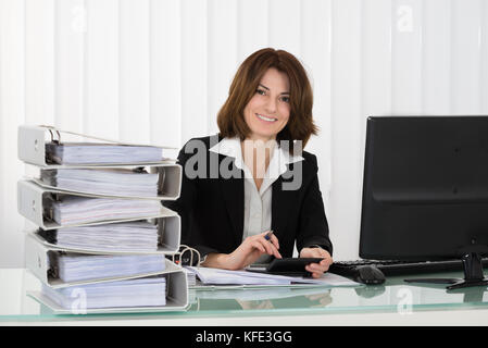 Junge glücklich Geschäftsfrau, die das Arbeiten mit Dokumenten in Office Stockfoto