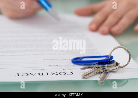 Nahaufnahme der Vertrag mit Schlüssel auf dem Schreibtisch Stockfoto