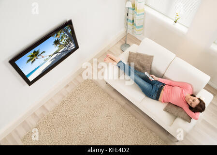 Junge Frau Einschlafen beim Fernsehen zu Hause beobachten Stockfoto