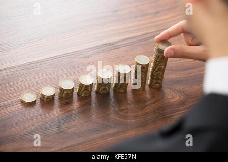 Nahaufnahme der Geschäftsmann, der Münzen Stapel Stockfoto