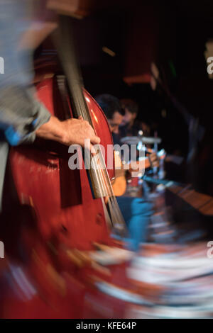 Vintage look Foto mit Swirl blur Effekt eines akustischen Trio Band auf einer Bühne in einem Nachtclub, mit der Double Bass Player im Fokus Stockfoto