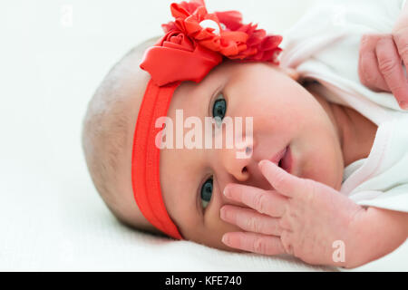 Süße kleine Baby tragen rote Blume Kopfbügel Stockfoto