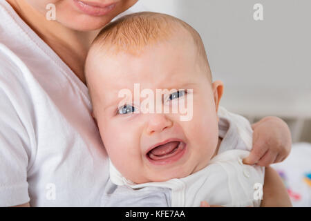 Nahaufnahme Eines weinenden Kindes am Arm der Mutter Stockfoto