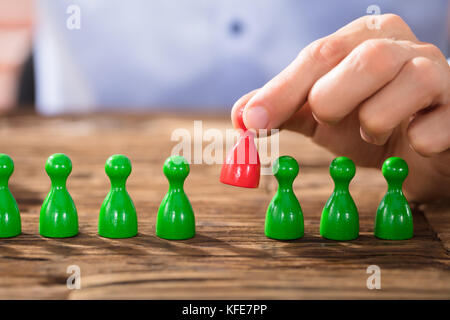 Nahaufnahme einer Person, die roten Zahlen in der grünen Reihe über dem Schreibtisch aus Holz Stockfoto