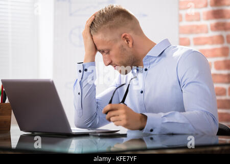 Close-up von depressiven Geschäftsmann am Laptop auf dem Schreibtisch im Büro Stockfoto