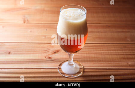 Ein Glas voll der roten Bier auf einer hölzernen Hintergrund Kopie Raum Stockfoto