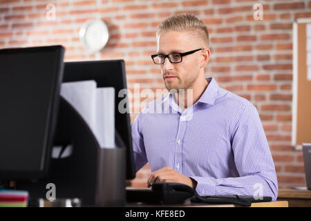 Ernsthafte junge Unternehmer Arbeiten am Computer im Büro Stockfoto