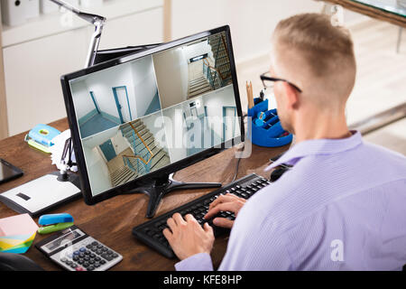 Nahaufnahme eines Kaufmanns an CCTV-Aufnahmen auf Computer am Arbeitsplatz Stockfoto