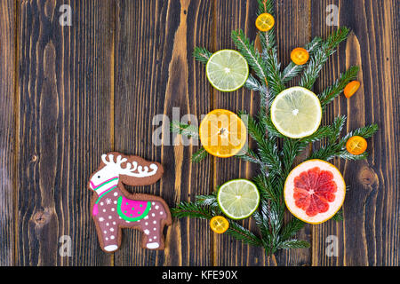 Hausgemachte Lebkuchen cookies verglast und Weihnachtsbaum Zweige mit Früchten. Stockfoto