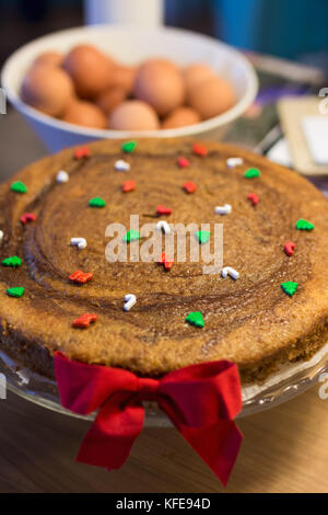 Köstliche weihnachten Kuchen gefüllt mit Früchten, mit kleinen grünen und roten Zucker Figuren geschmückt Stockfoto