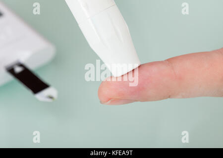 Zugeschnittenes Bild der Arzt prüfen Blutzuckerspiegel von männlichen Patienten in der Klinik Stockfoto