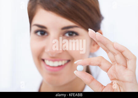 Closeup Portrait von lächelnden jungen Ärztin holding Pille Stockfoto