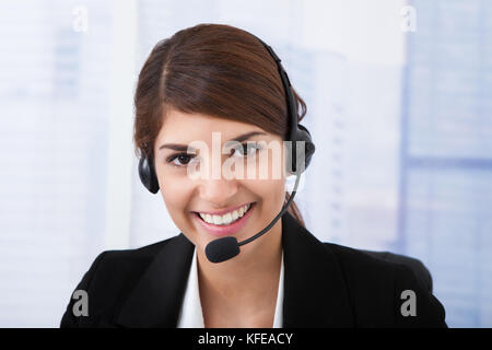 Porträt von überzeugt junge Geschäftsfrau tragen Kopfhörer im Büro Stockfoto