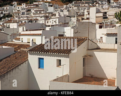 Ein blaues Fenster mit Fensterläden hebt sich von den weißen Wänden und braun Dächer der Gebäude in der malerischen historischen Hügel Stadt Mijas, Spanien Stockfoto