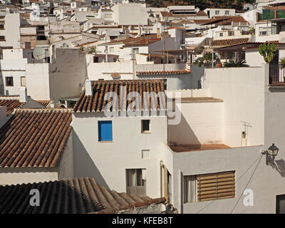 Ein blaues Fenster mit Fensterläden hebt sich von den weißen Wänden und braun Dächer der Gebäude in der malerischen historischen Hügel Stadt Mijas, Spanien Stockfoto