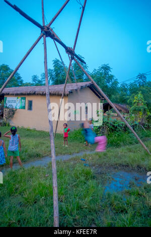 Chitwan, Nepal - November 03, 2017: Nicht identifizierte Kinder spielen in der Nähe von Holzhäusern in Chitwan gebaut, Nepal Stockfoto