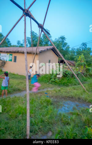 Chitwan, Nepal - November 03, 2017: Nicht identifizierte Kinder spielen in der Nähe von Holzhäusern in Chitwan gebaut, Nepal Stockfoto