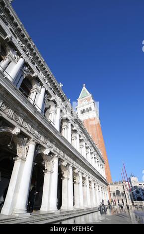 Saint Mark Square und alten Palast der nationalen Bibliothek namens Biblioteca Marciana mit Flut und hohen Glockenturm im Winter in Venedig Italien Stockfoto