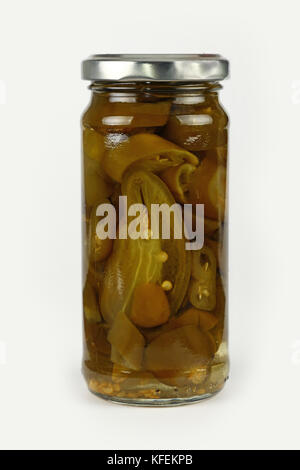 In der Nähe von einem kleinen Glas Glas eingelegte geschnitten Grün hot Jalapeno chili peppers Über weißer Hintergrund, Low Angle Seitenansicht Stockfoto