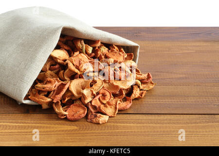 Getrocknete Stücke von Äpfeln in der rauhen Leinen Stoff liegen auf einem Holztisch Stockfoto