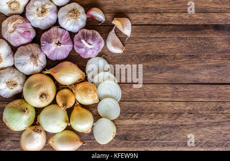 Zwiebeln und Zwiebeln schneiden, Lila ganze Knoblauch und Knoblauchzehen auf einem hellen Hintergrund, mit viel Raum, Textur und Kopieren Stockfoto