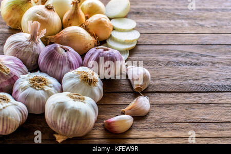 Zwiebeln und Zwiebeln schneiden, Lila ganze Knoblauch und Knoblauchzehen auf einem hellen Hintergrund, mit viel Raum, Textur und Kopieren Stockfoto