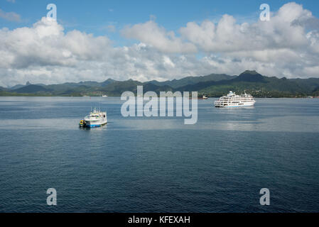 SUVA, VITI LEVU, FIDSCHI-28. NOVEMBER 2016: Kreuzfahrtschiff und Fischerboot im Pazifischen Ozean mit üppiger Berglandschaft in Suva, Fidschi Stockfoto