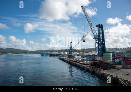 SUVA, VITI LEVU, FIDSCHI-28. NOVEMBER 2016: Hafenbereich mit Kran, Frachtcontainern und Autos mit Inselblick in Suva, Fidschi Stockfoto