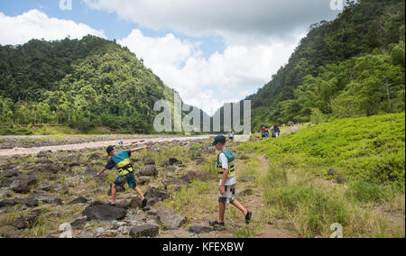 SUVA, VITI LEVU, FIDSCHI-28. NOVEMBER 2016: Touristen wandern mit dem Langboot auf dem Fluss Navua und tropische Regenwaldlandschaft in Suva, Fidschi Stockfoto