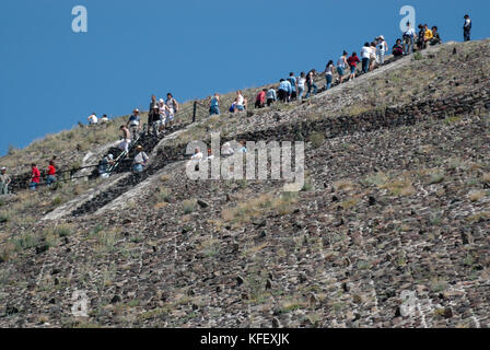 Masse der Touristen klettern die Spitze der Pyramide der Sonne und die Pyramide des Mondes an einem sonnigen Wintertag. Teotihuacan, Mexiko Stadt. Mexiko Stockfoto