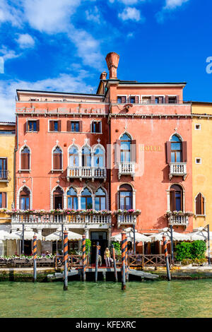 Bunte Gebäude wie dieses dunkelrote Gebäude entlang des Canal Grande in Venedig, Italien Stockfoto