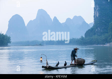 Ein alter Fischer bereitet für den Fischfang auf traditionelle Art und Weise mit Hilfe der Kormoran in Li River in der Nähe von Yangshuo, Xingping, Guangxi, China Stockfoto