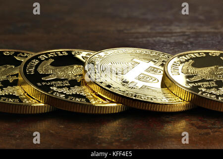 Bitcoin in einer Reihe von 1 Unze american Gold Eagle Bullion Coins Stockfoto