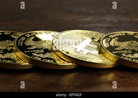 Bitcoin in einer Reihe von 1 Unze american Gold Eagle Bullion Coins Stockfoto