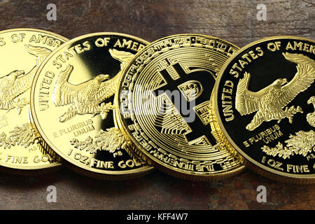 Bitcoin in einer Reihe von 1 Unze american Gold Eagle Bullion Coins Stockfoto