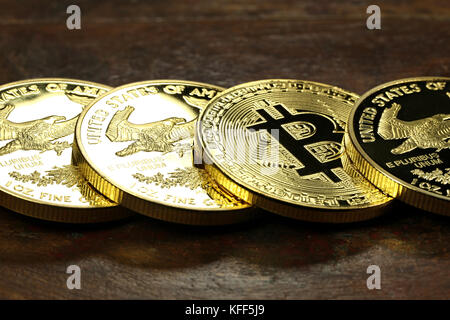 Bitcoin in einer Reihe von 1 Unze american Gold Eagle Bullion Coins Stockfoto