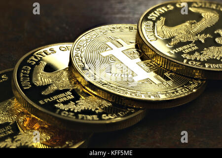 Bitcoin in einer Reihe von 1 Unze american Gold Eagle Bullion Coins Stockfoto